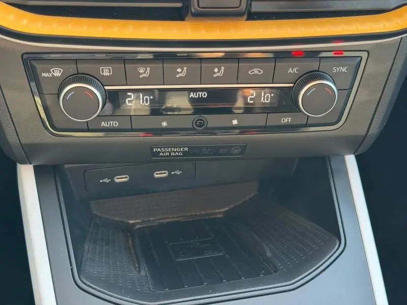 Vue rapprochée de la console centrale du SEAT Arona 2025, avec commandes climatisation digitale et ports USB.