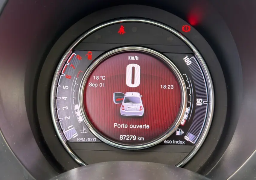 Affichage numérique central du tableau de bord de la Fiat 500 gris foncé, indiquant porte ouverte et vitesse zéro km/h.