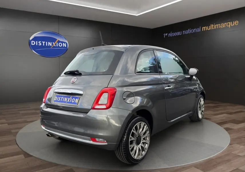 Vue 3/4 arrière droite d'une Fiat 500 gris foncé avec jantes alliage et feux arrière LED, en showroom.