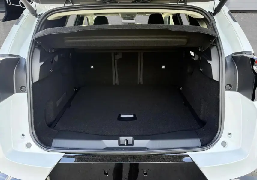 Coffre ouvert vu de l'arrière d'un Citroën C5 Aircross blanc, montrant l'espace de chargement vide et la plage arrière relevée.