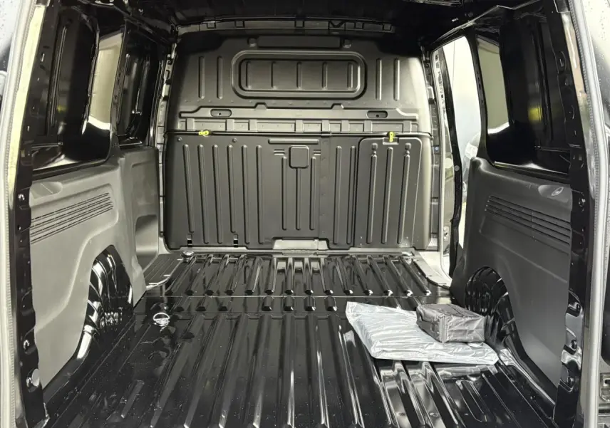 Vue intérieure arrière du Citroën Berlingo Van XL noir Perla, montrant l'espace de chargement tôlé et vide.