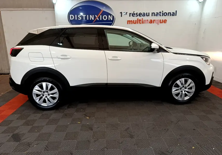 Profil côté gauche d'un Peugeot 3008 blanc 2020 garé en intérieur avec jantes alliage et vitres teintées.