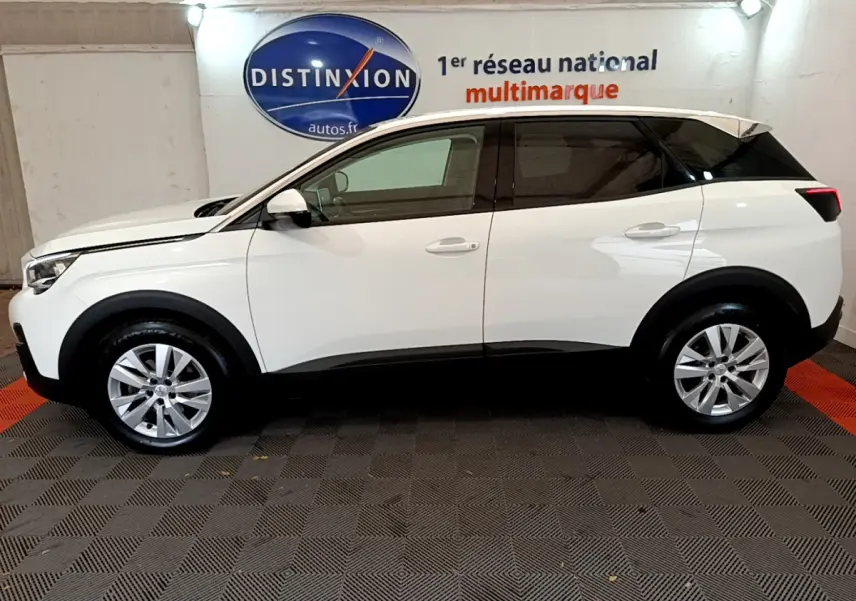 Profil côté gauche d'un Peugeot 3008 blanc de 2020, version BlueHDi 130 Active Business, sur fond intérieur showroom.