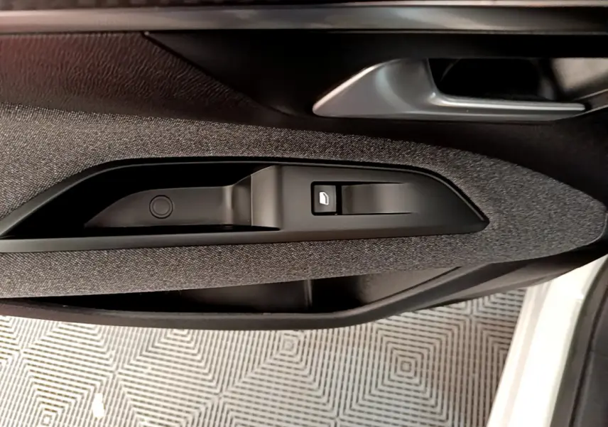 Détail de la commande de verrouillage sur la porte côté gauche d'un Peugeot 3008 blanc 2020.