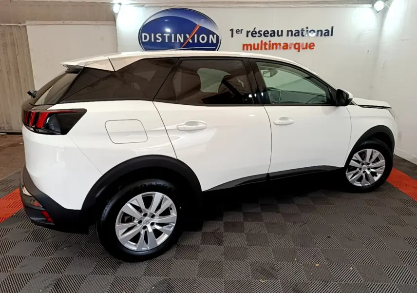 Peugeot 3008 blanc vue de profil côté gauche dans un showroom avec jantes alliage et vitres teintées.