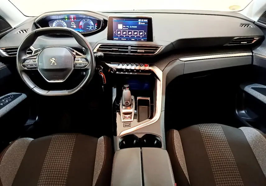 Intérieur du Peugeot 3008 2020 vu de face, tableau de bord noir avec écran tactile central et volant cuir multifonctions.