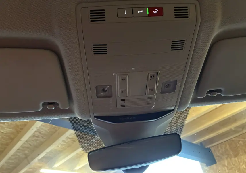Vue intérieure du plafond avant du Volkswagen T-Roc gris 2023, montrant les commandes d'éclairage et le rétroviseur central.