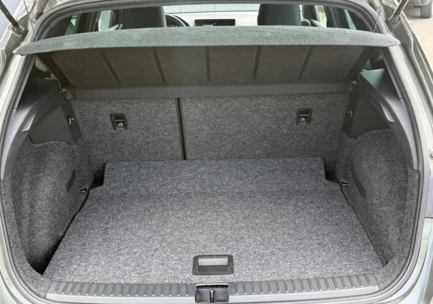 Coffre ouvert vu de l'arrière d'une SEAT Arona Gris Cliff 2025, plancher plat et habillage intérieur gris.