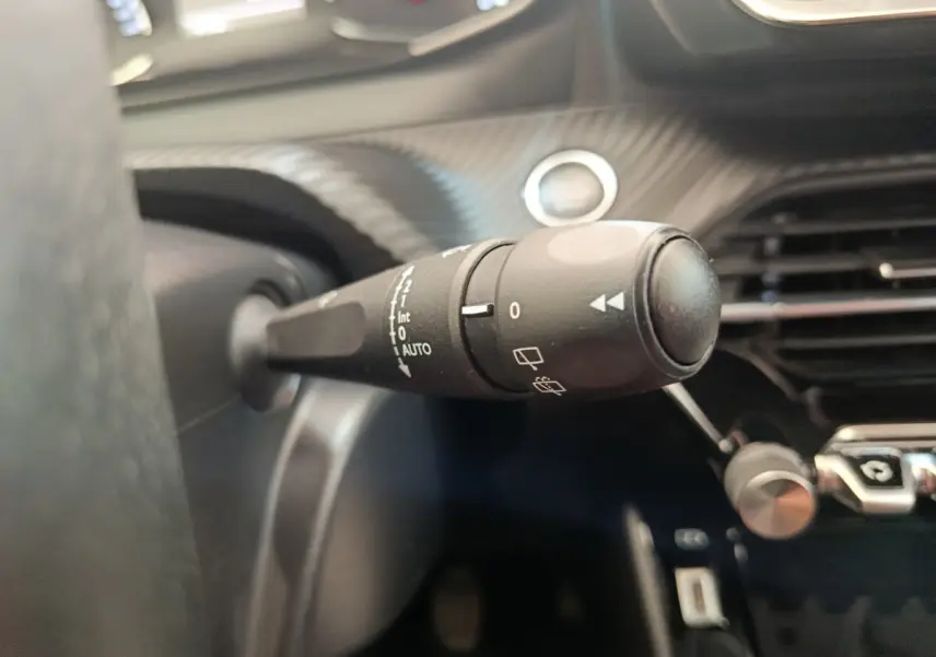 Gros plan sur la commande d’essuie-glace côté gauche du tableau de bord intérieur du Peugeot 2008 bleu 2021.