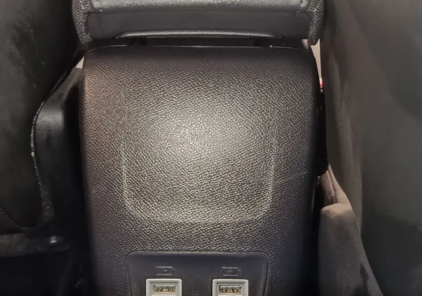 Vue rapprochée de la console centrale arrière noire avec deux ports USB dans un Peugeot 2008 bleu 2021.