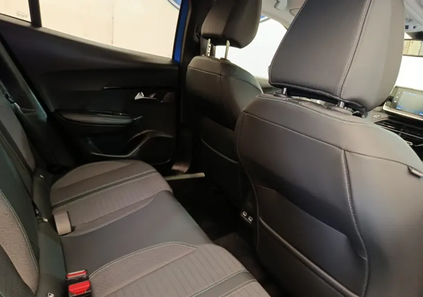 Vue intérieure arrière droite de la Peugeot 2008 bleu, montrant la banquette tissu et cuir avec coutures contrastées.