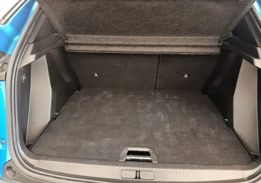 Coffre ouvert de Peugeot 2008 bleu, vue arrière, montrant l'espace de chargement avec plancher plat et banquette rabattue.