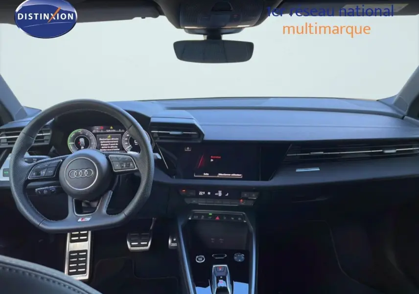 Vue intérieure frontale de l'Audi A3 Sportback 40 TFSIe S-Line 2025, tableau de bord et volant cuir noir avec affichage digital.