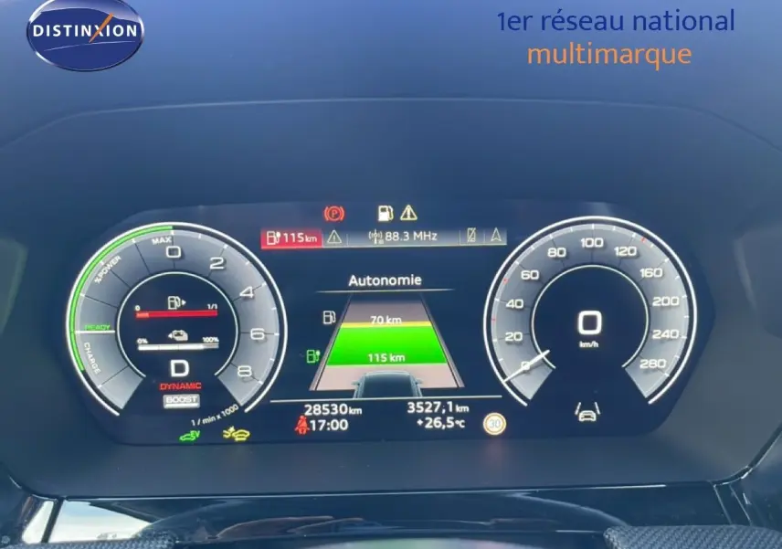 Tableau de bord numérique d'Audi A3 Sportback blanc, affichant l'autonomie et la vitesse à 0 km/h, vue frontale rapprochée.