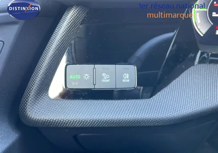 Gros plan sur les commandes d’éclairage à gauche du volant d’un Audi A3 Sportback blanc Ibis 2025.