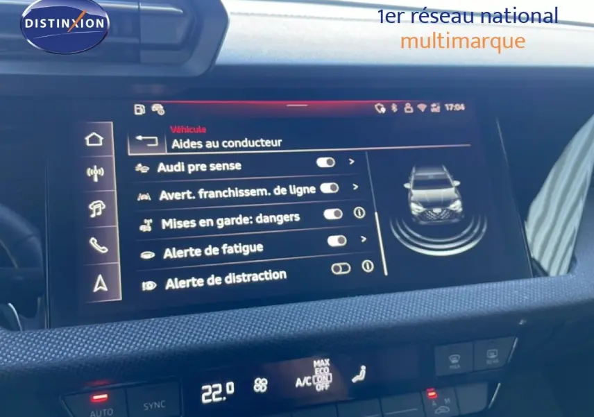 Écran central de l’Audi A3 Sportback blanc Ibis 2025 affichant les aides à la conduite, vue intérieure frontale.