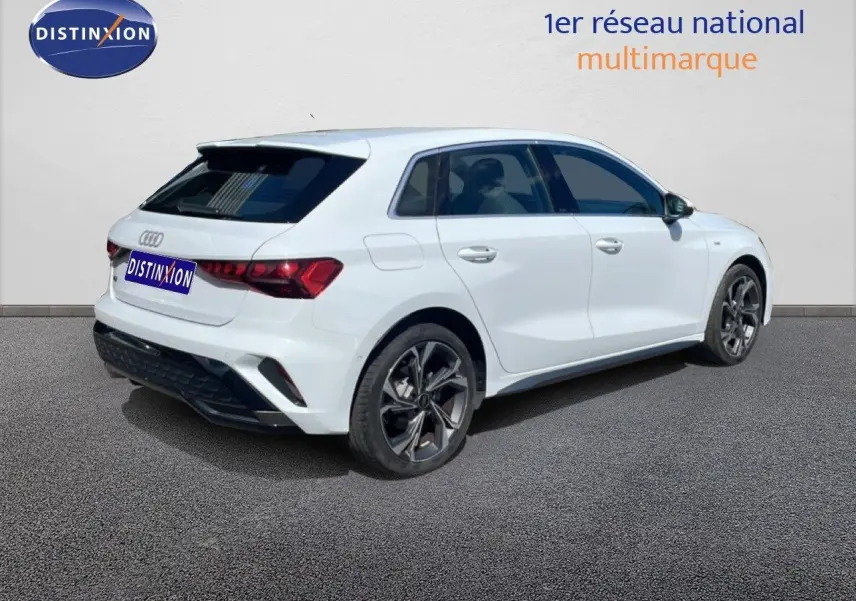 Audi A3 Sportback blanc Ibis vue 3/4 arrière droit, avec jantes alliage et vitres teintées.