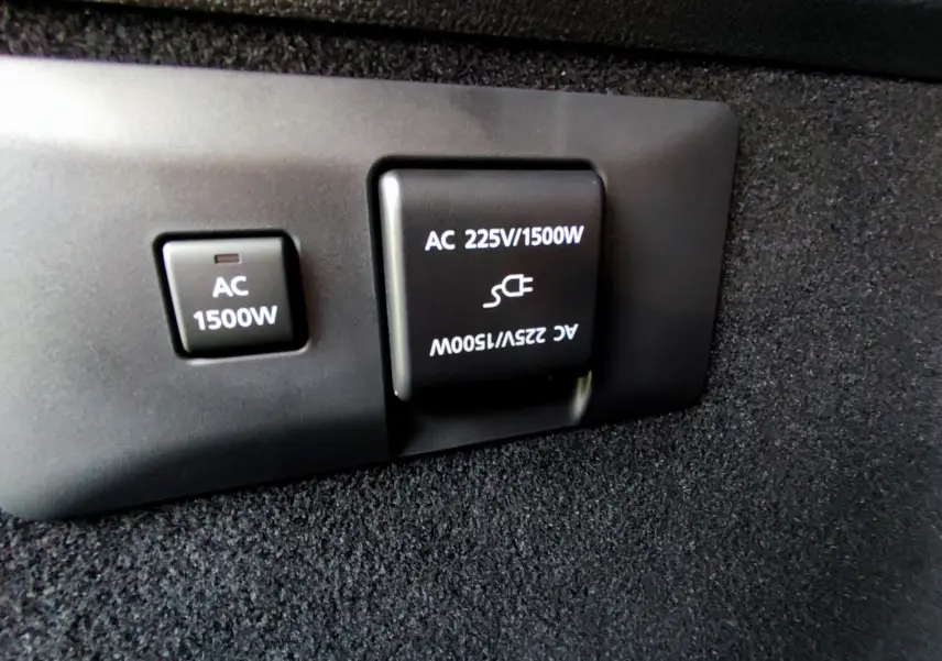 Prise électrique 225V/1500W en gros plan dans le coffre du Mazda MX-30 gris foncé hybride rechargeable 2023.