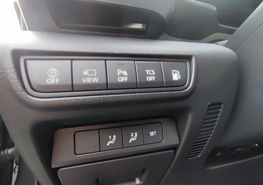 Panneau de commandes côté conducteur du Mazda MX-30 2023 gris foncé, avec boutons d'assistance et réglages de sièges mémoire.