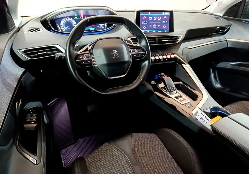 Intérieur du Peugeot 5008 Puretech 130, vue du poste de conduite avec volant cuir et écran tactile central.