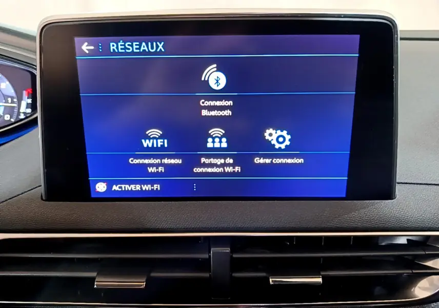Écran tactile central affichant les options réseau Bluetooth et Wi-Fi du Peugeot 5008 gris clair, vue intérieure frontale.