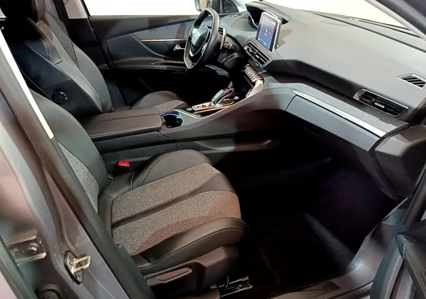 Intérieur avant droit du Peugeot 5008 gris clair 2020, sièges tissu et cuir, tableau de bord avec écran tactile central.