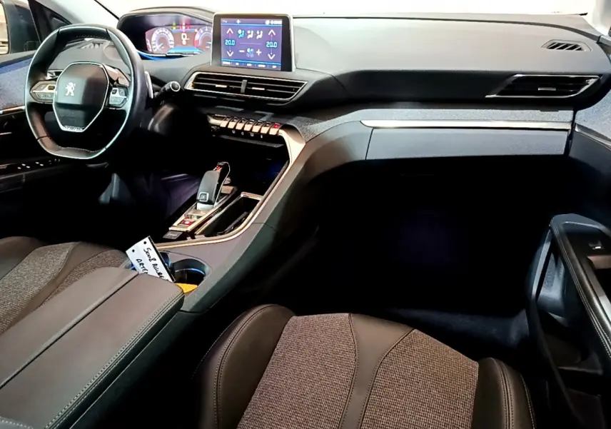 Intérieur du Peugeot 5008 2020 vu côté passager, tableau de bord noir avec écran tactile et volant compact cuir.