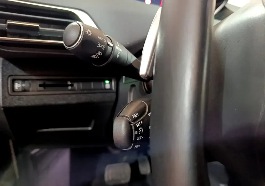 Gros plan sur les commandes au volant et le commodo d'éclairage du Peugeot 5008 gris clair, version 2020 Essence.
