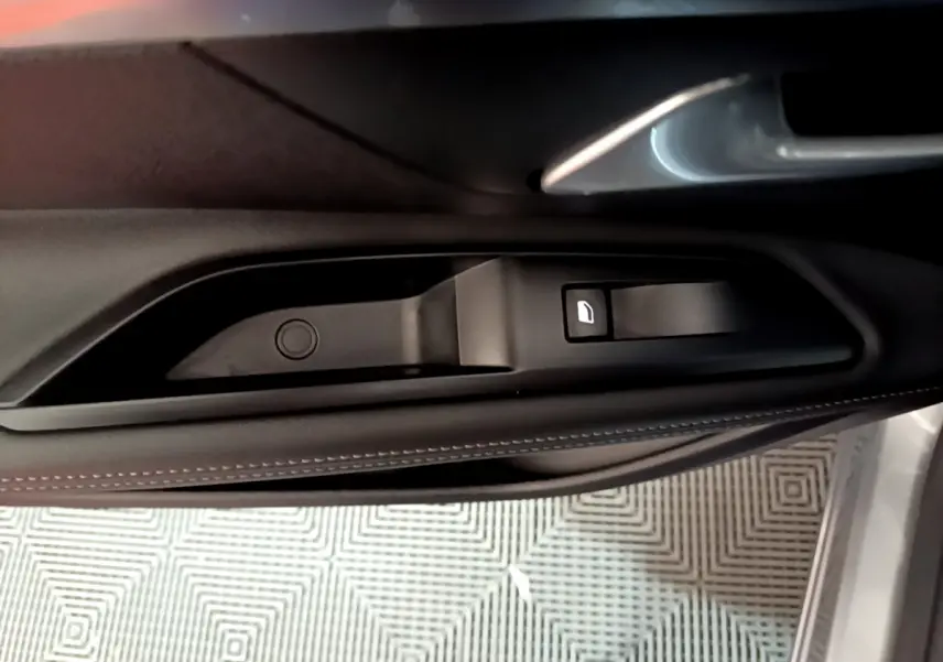 Poignée intérieure de porte côté gauche du Peugeot 5008 gris clair, avec bouton de verrouillage visible.