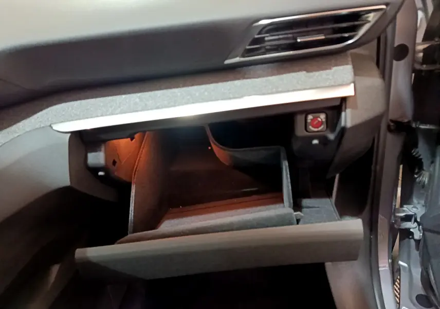 Intérieur du Peugeot 5008 gris clair 2020, vue sur la boîte à gants ouverte côté passager avec éclairage intérieur.