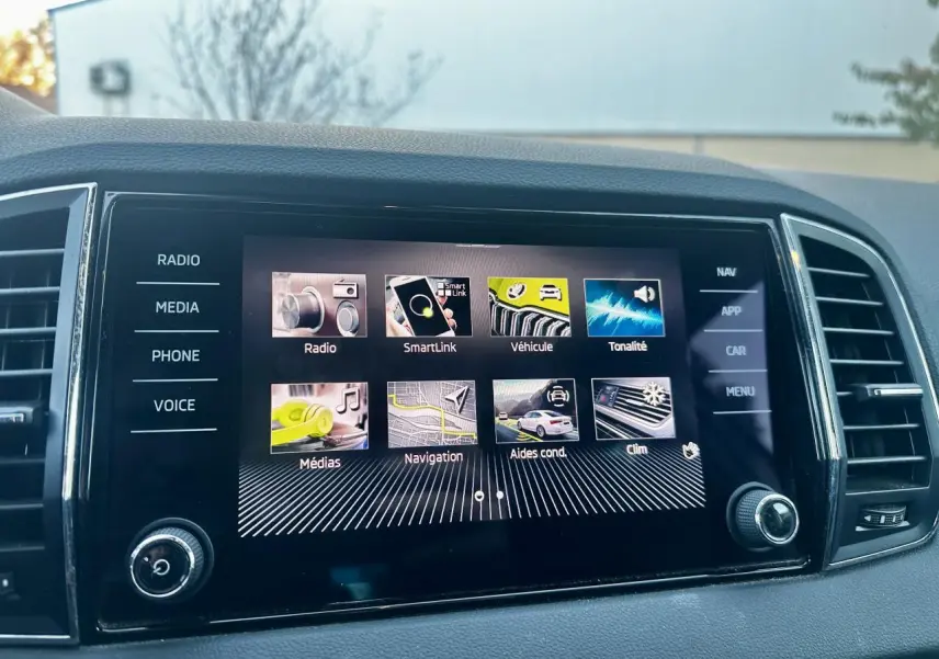 Écran tactile central du Skoda Karoq 2024 affichant le menu principal, vue intérieure frontale.