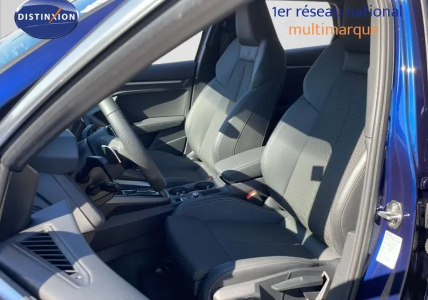 Vue intérieure côté conducteur de l'Audi A3 Sportback 2025 bleu Navarre, sièges sport S-Line en tissu gris noir.