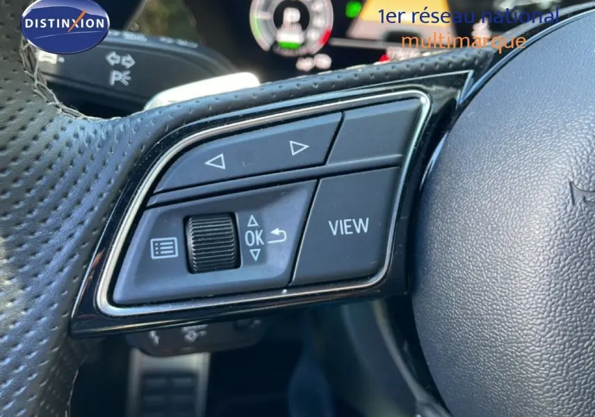 Gros plan sur les commandes multifonctions à gauche du volant en cuir perforé de l'Audi A3 Sportback 2025.