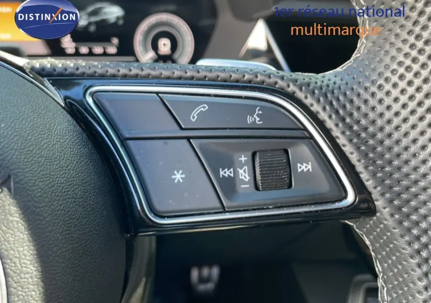 Gros plan sur les commandes gauche du volant perforé de l'Audi A3 Sportback 40 TFSIe bleu Navarre 2025.