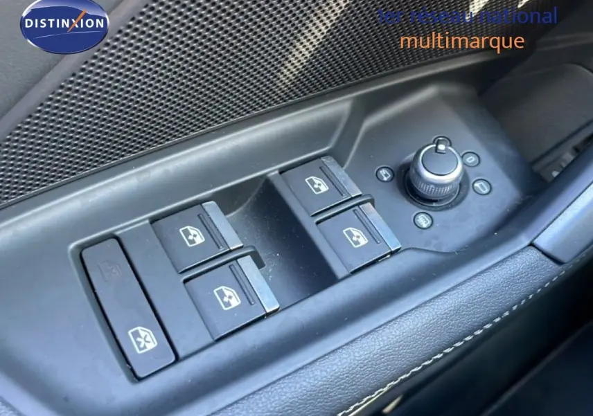 Gros plan sur les commandes des vitres électriques et rétroviseurs côté conducteur de l'Audi A3 Sportback bleu Navarre 2025.
