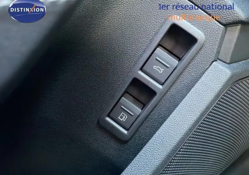 Gros plan sur les boutons d’ouverture du coffre et de la trappe à carburant sur la portière intérieure d’une Audi A3 Sportback bleu Navarre.