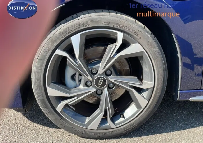 Gros plan sur la roue avant droite d'une Audi A3 Sportback bleu Navarre métal avec jante alliage distinctive.