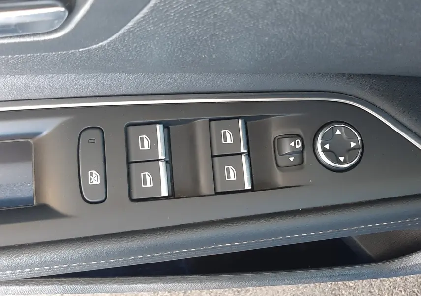 Gros plan sur les commandes de lève-vitres et réglage des rétroviseurs côté conducteur du Peugeot 3008 2023, intérieur noir.