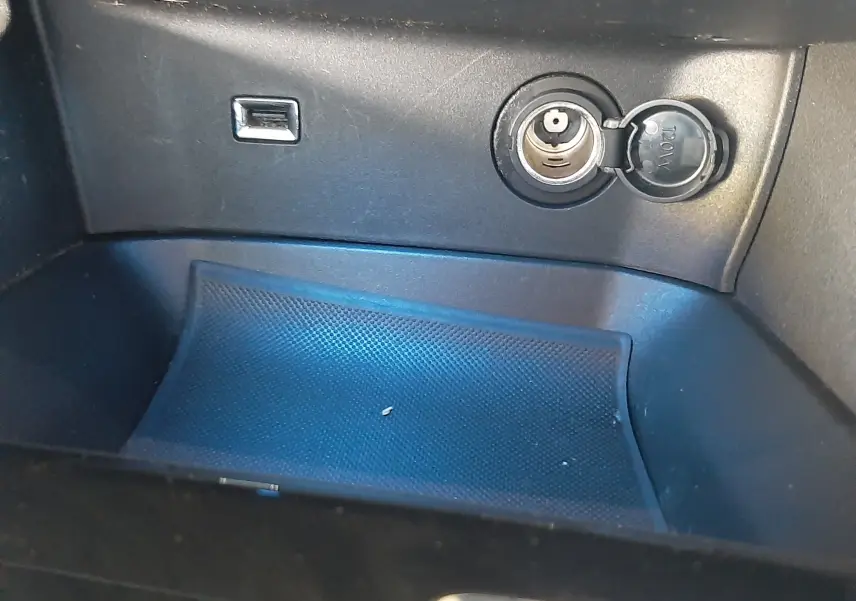 Détail intérieur montrant une prise 12V et un port USB dans la console centrale du Peugeot 3008 2023.