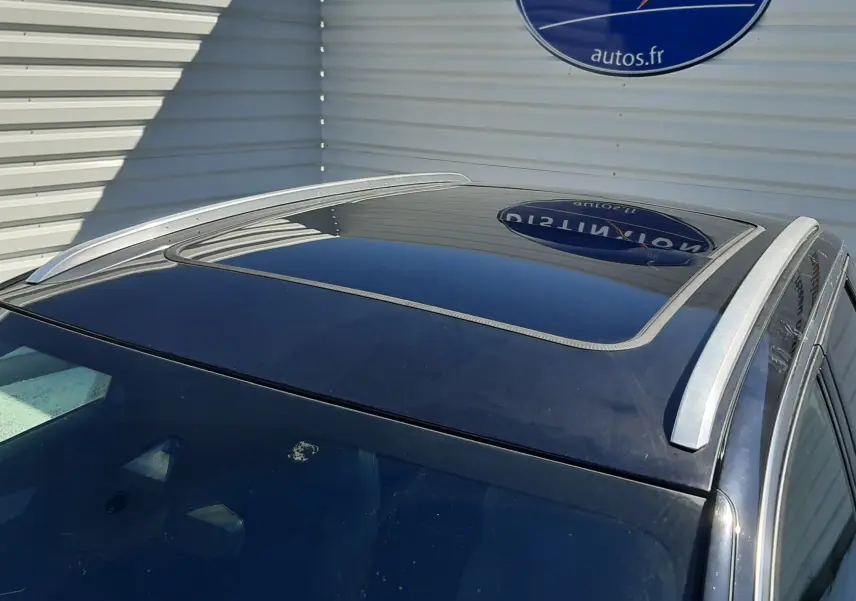 Toit panoramique ouvrant et barres de toit argentées sur Peugeot 3008 bleu Vertigo avec toit Black Diamond, vue en plongée.