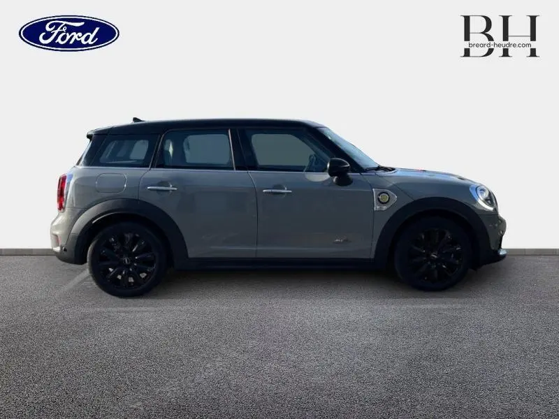 Vue latérale gauche d'une MINI Countryman Cooper SE Moonwalk Grey avec jantes noires et toit panoramique.