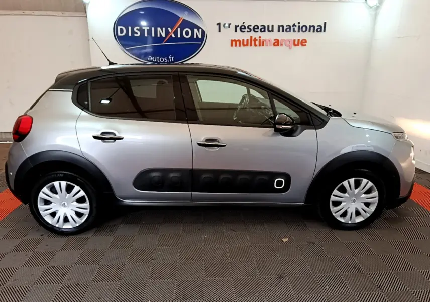 Profil côté gauche d'une Citroën C3 gris clair 2019 avec protections noires caractéristiques et jantes acier.