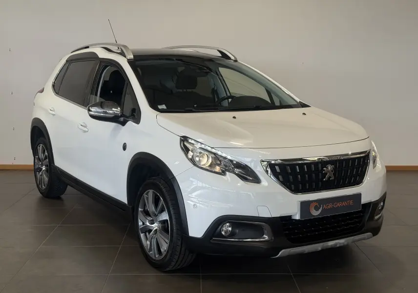 Peugeot 2008 blanc vue 3/4 avant droit, finition Crossway avec barres de toit et jantes alliage visibles.