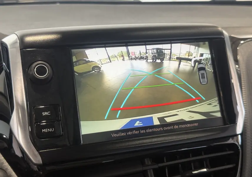 Écran de caméra de recul du Peugeot 2008 blanc, affichant les lignes d'aide au stationnement en intérieur.