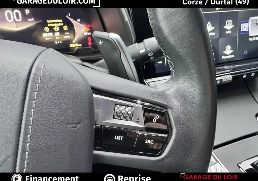 Gros plan sur le volant cuir noir du DS7 Crossback Bleu, avec commandes intégrées et tableau de bord numérique en arrière-plan.