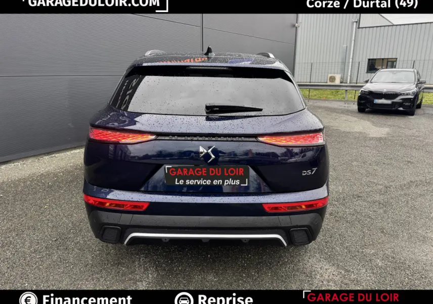 Vue arrière d’un DS7 Crossback Bleu 2024 avec feux LED allumés et logo DS centré sur le hayon.