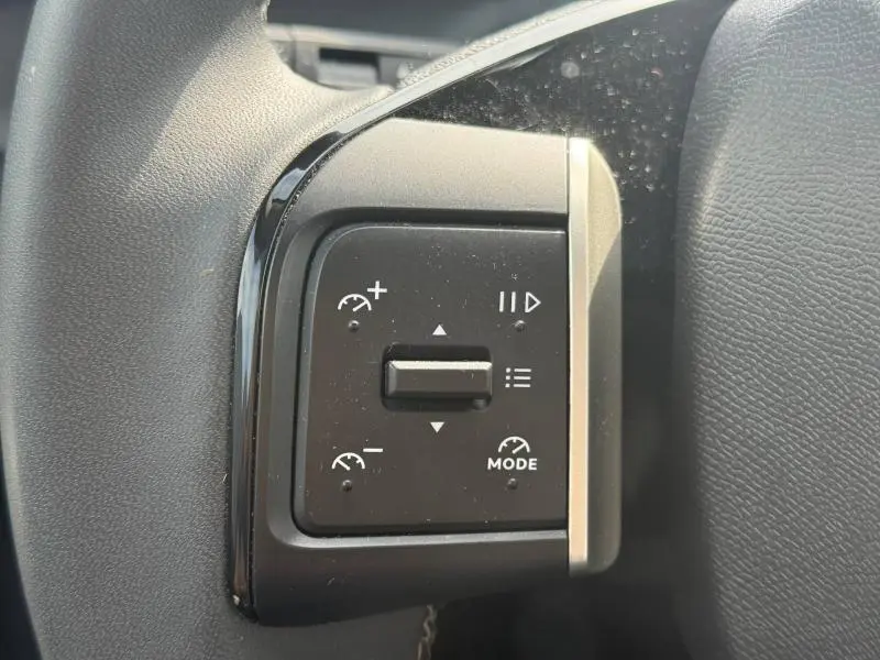Gros plan sur les commandes au volant noir de la Citroën C3 2025, avec boutons de régulateur de vitesse et mode.