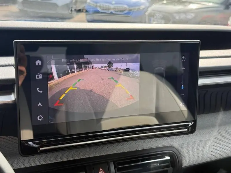 Écran intérieur de la Citroën C3 2025 montrant la caméra de recul avec guidage coloré, vue depuis le tableau de bord.