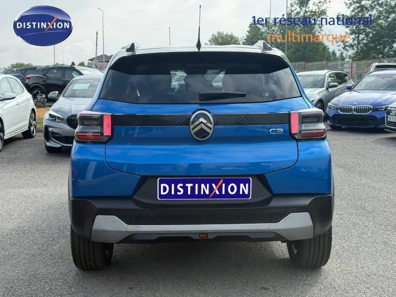 Vue arrière d'une Citroën C3 2025 bleu avec toit noir, feux arrière rectangulaires et logo chromé central.