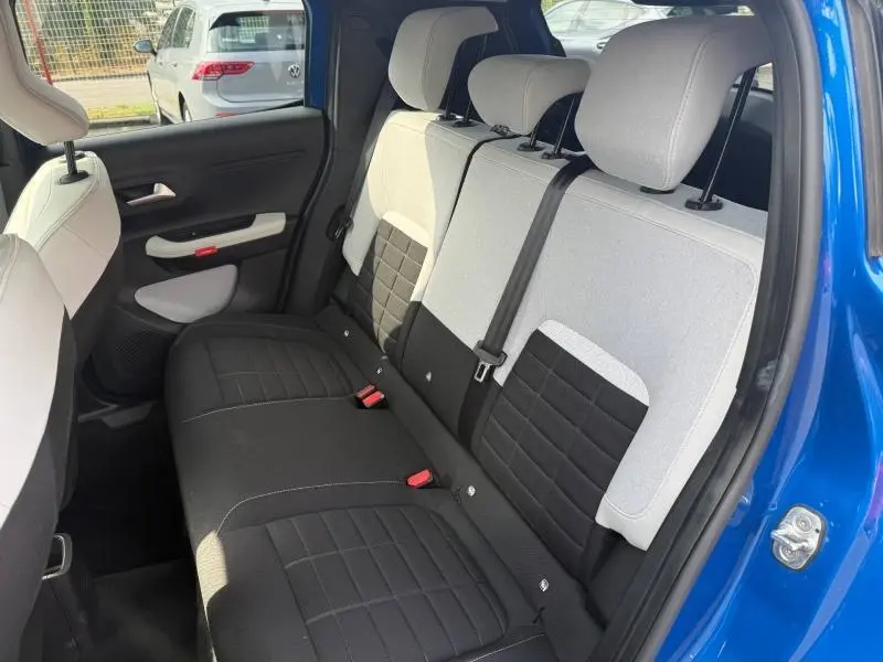Vue intérieure arrière côté droit du Citroën C3 2025 noir, montrant les sièges bicolores noirs et gris.
